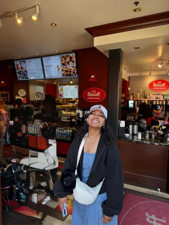Smiling in a white cap outside a Biscoff Coffee Corner